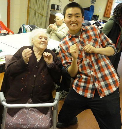 A student volunteering at a local community centre with older residents