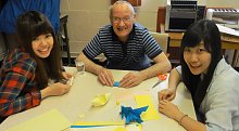 Students volunteering at a craft session in a local community centre with older people.